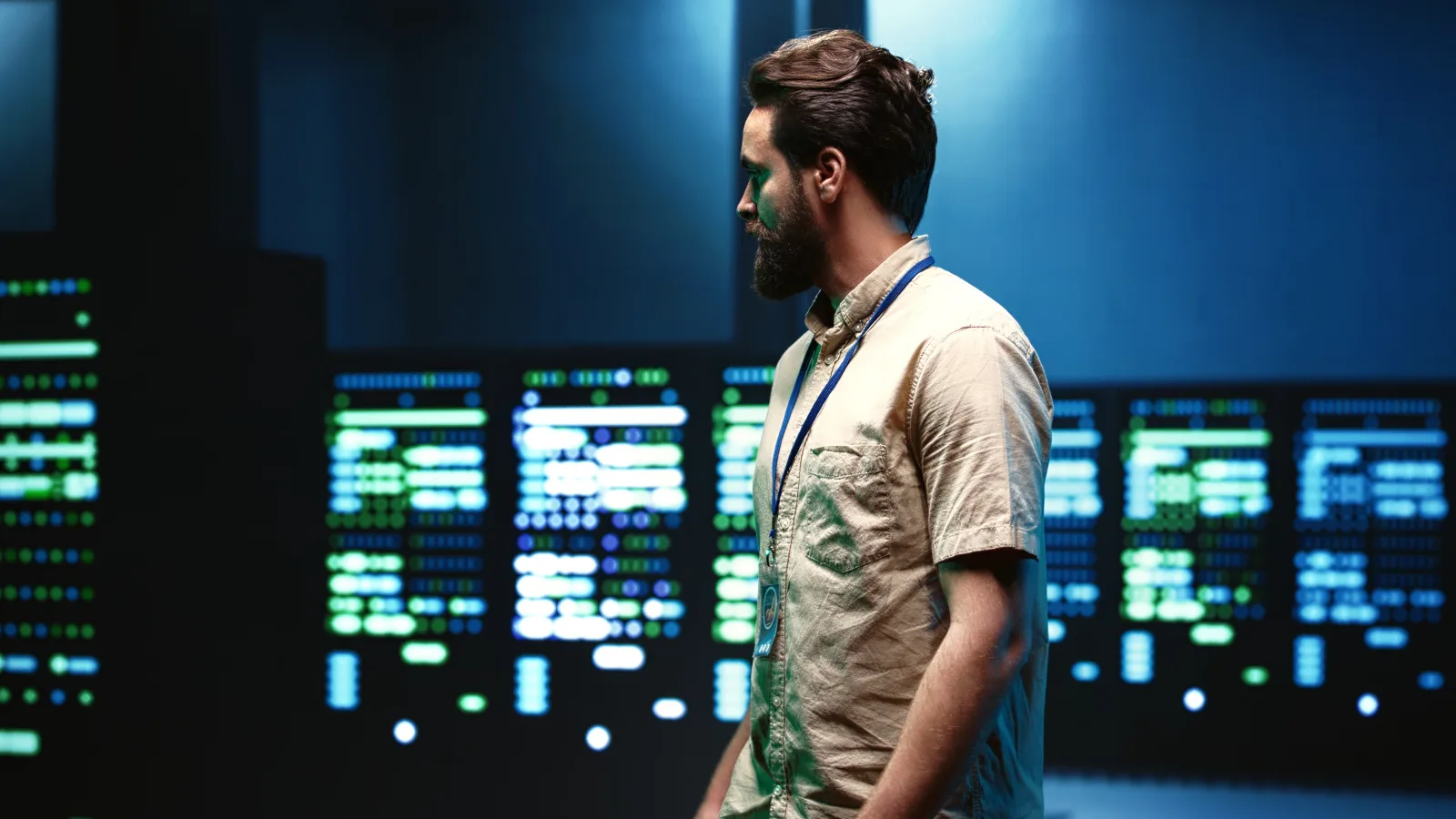 Un tecnico cammina davanti agli armadi di un data center con le spie accese