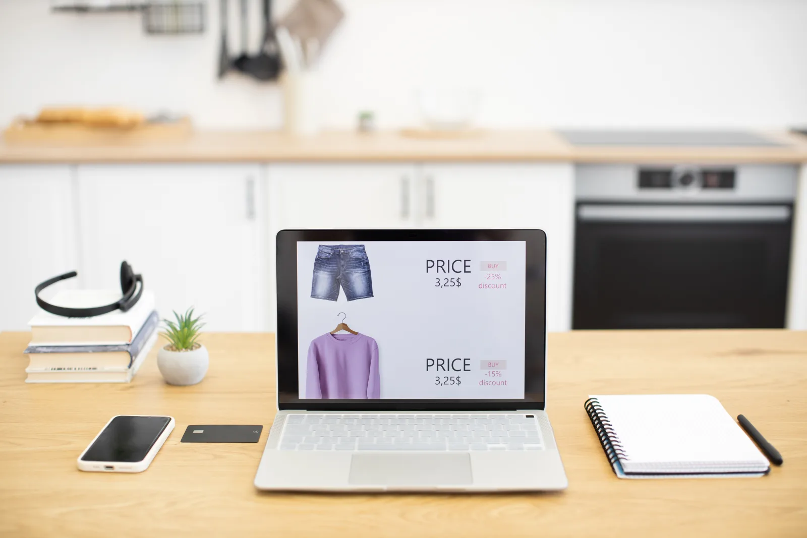 Un portatile su un tavolo mostra la pagina di un negozio di abbigliamento online con i prezzi